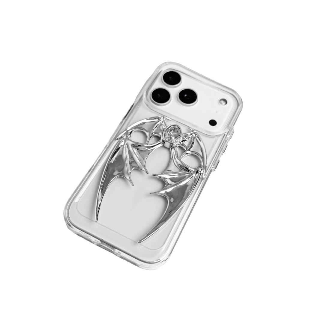 The Gem Demon Wings iPhone Case featuring 3D sculpted silver metallic bat-style wings with a central rhinestone. Shown with both White and Black gem options, available on Silver, Transparent, and Black case bases.