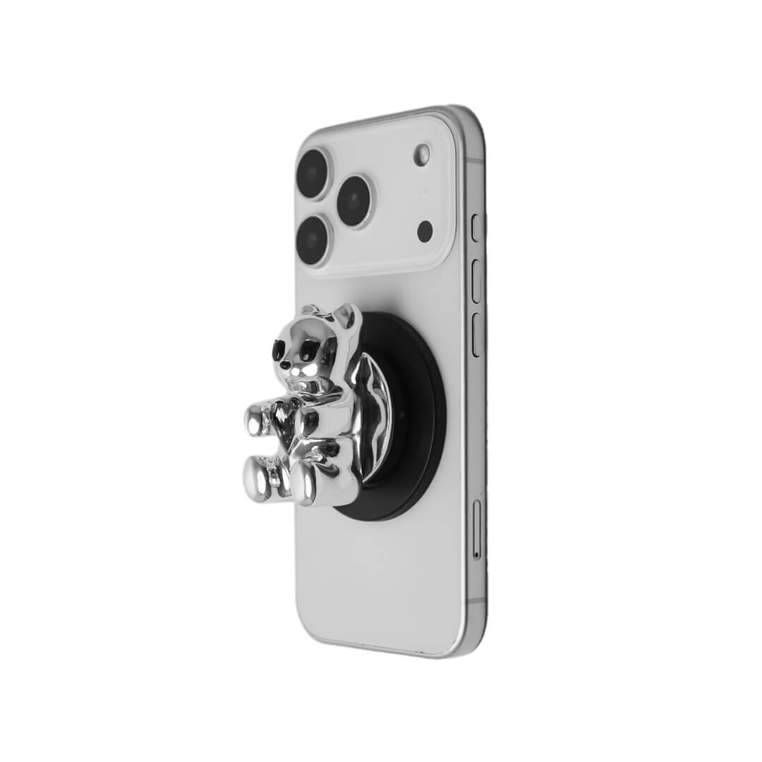 The Gem Gummy Bear phone grip collection featuring the sculpted 3D bear holding a sparkling central heart gem, shown in both the reflective Silver Chrome and glossy Black finish options.