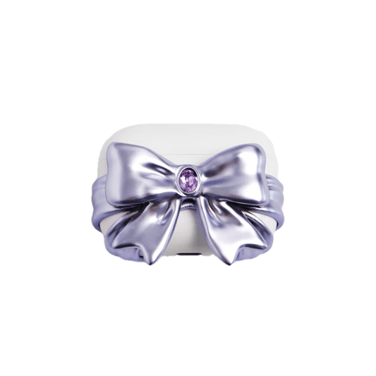 PURPLE GEM BOW AIRPODS COVER LIMITED. White AirPods case wrapped with a 3D metallic-look violet bow featuring a central purple gem.