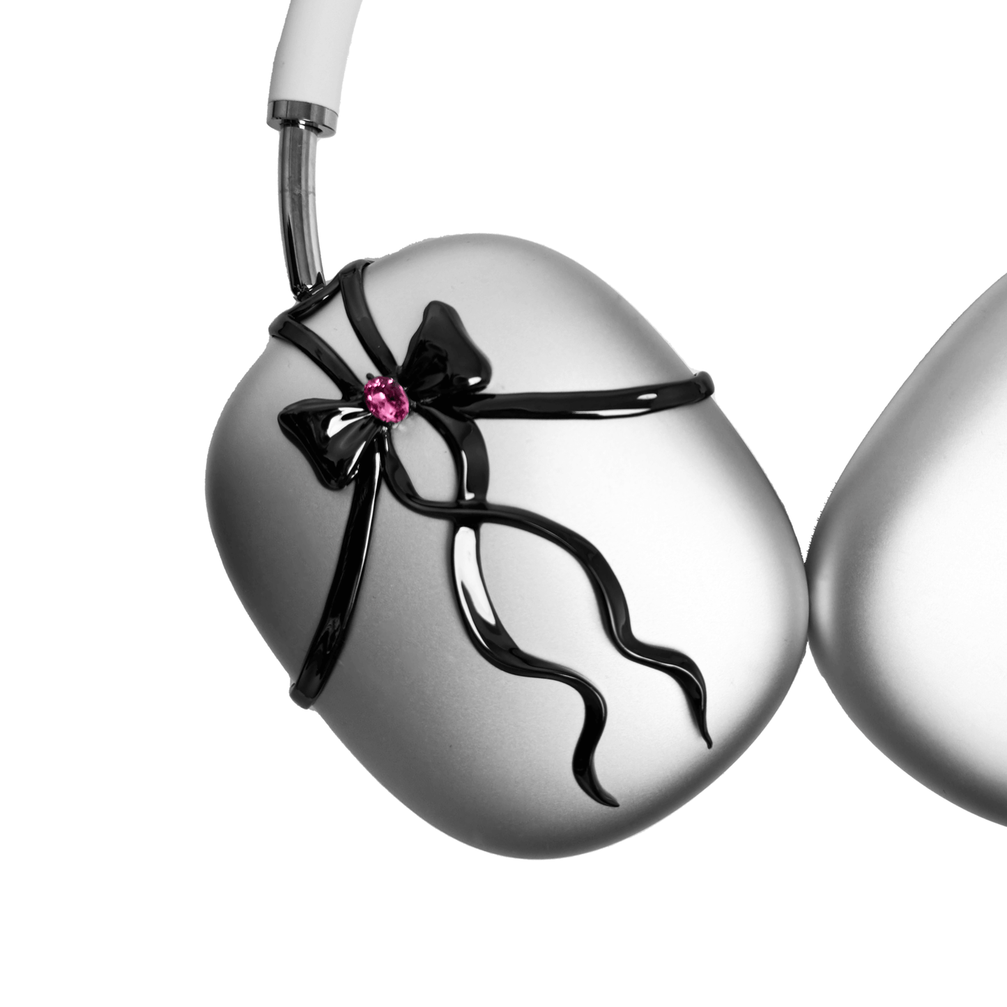 AirPods Max cover with sculpted metallic black/silver shells, adorned with a flowing 3D ribbon design and highlighted by a shimmering Pink Gem (Swarovski Crystal), creating a luxurious, statement look.