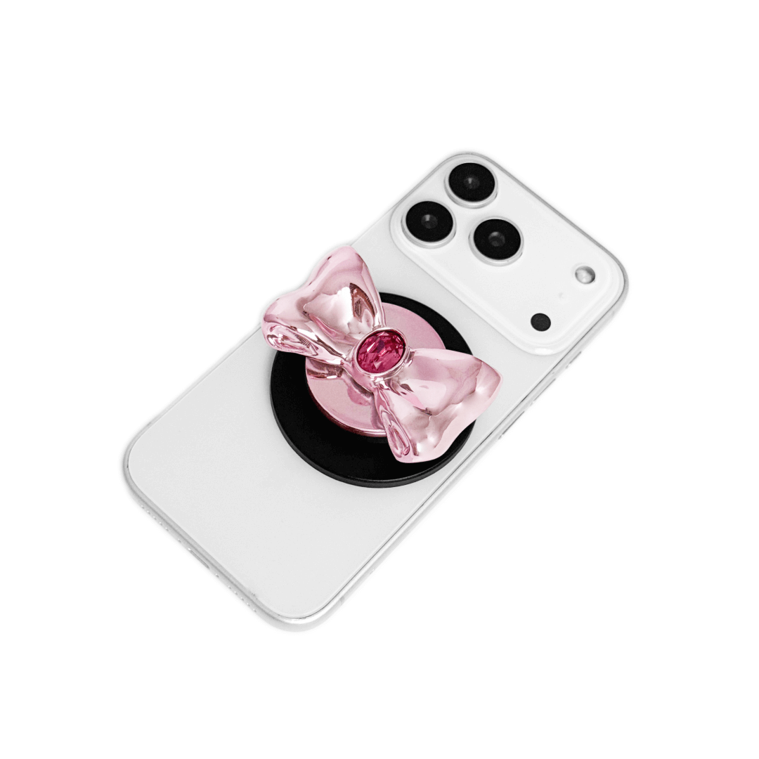 Gem Bow Phone Grip S available in silver, pink, black, and white bows, each featuring Swarovski crystal options: silver with pink, purple, white, blue, or black gems; pink with pink gem; black and white with black, white, or pink gems.