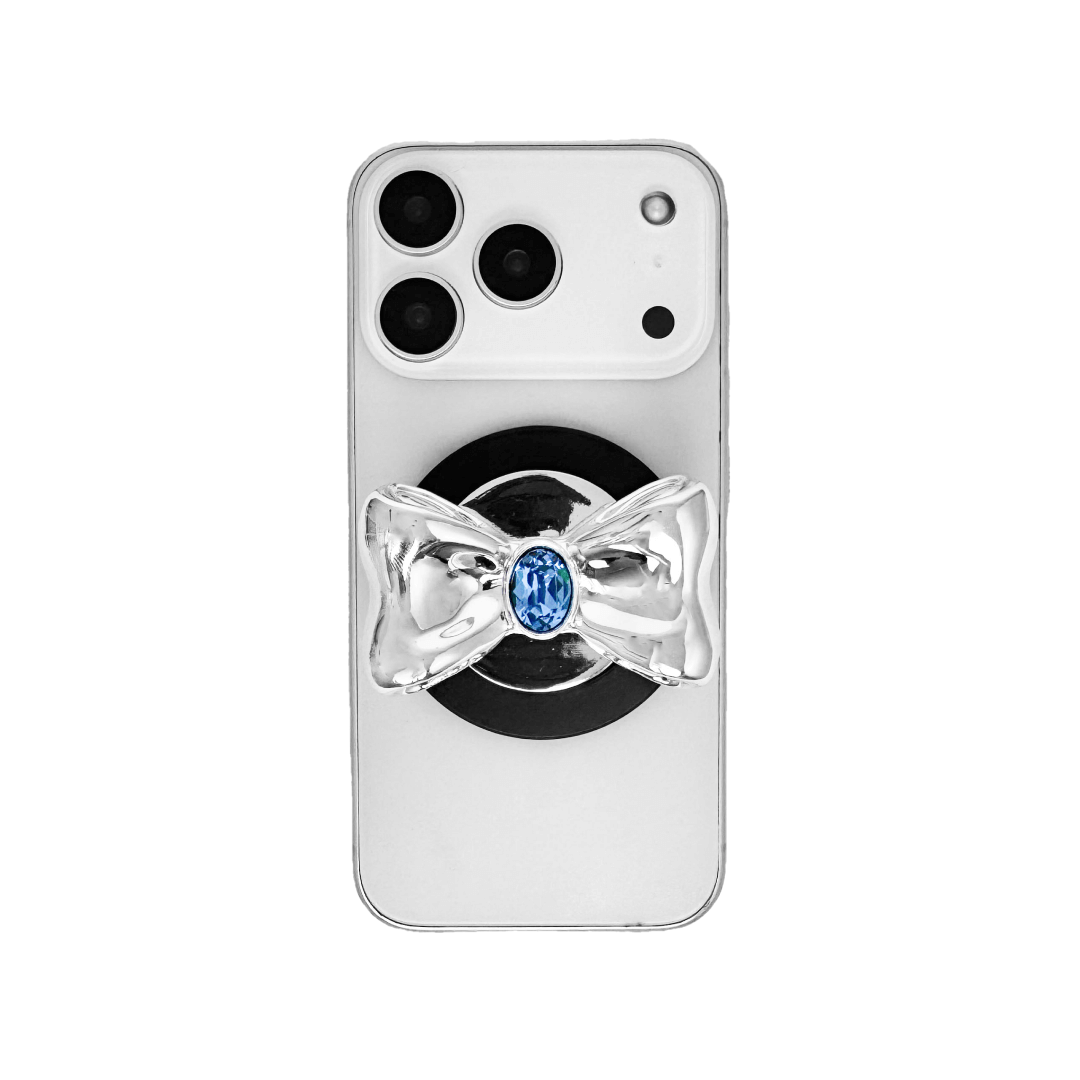 Gem Bow Phone Grip S available in silver, pink, black, and white bows, each featuring Swarovski crystal options: silver with pink, purple, white, blue, or black gems; pink with pink gem; black and white with black, white, or pink gems.