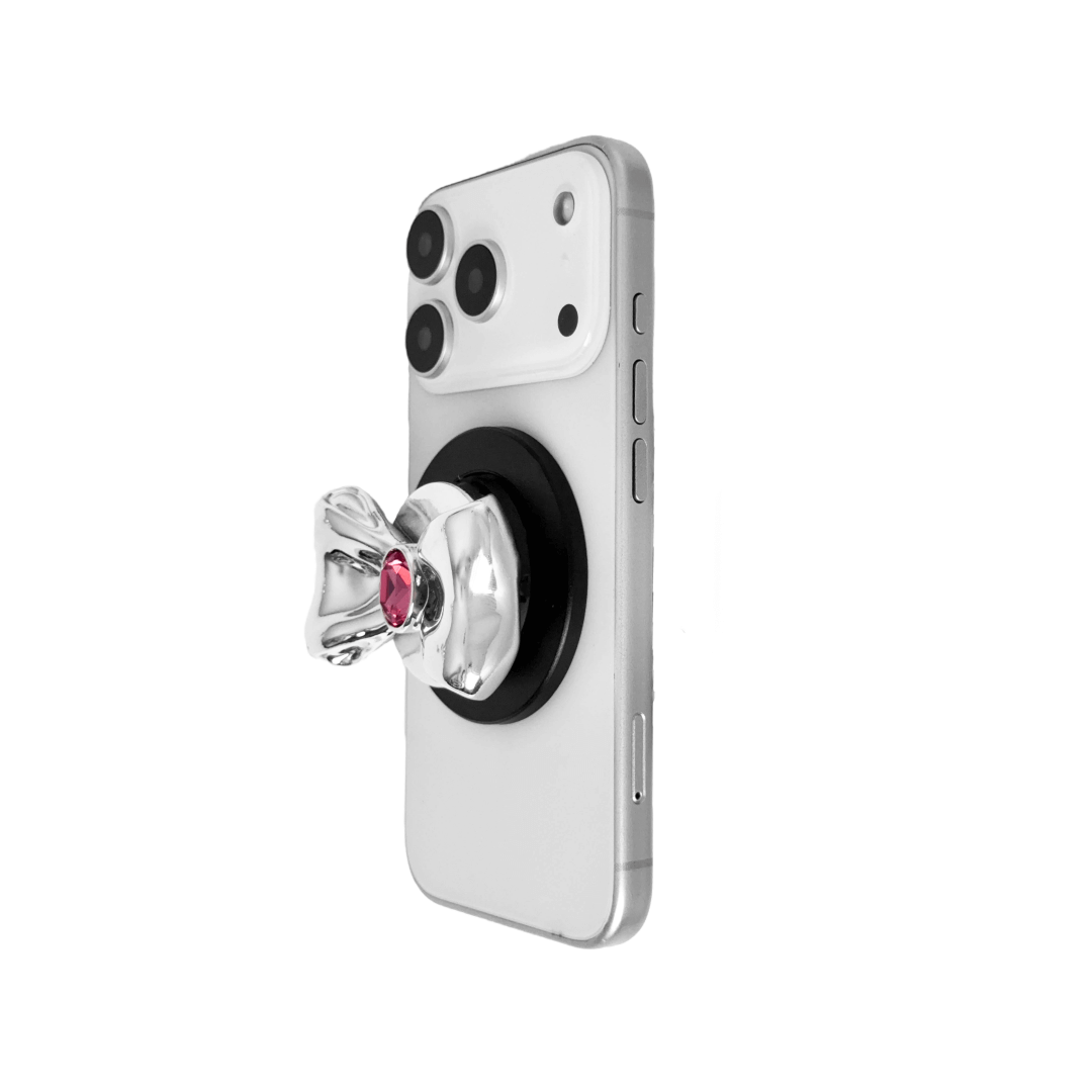 Gem Bow Phone Grip S available in silver, pink, black, and white bows, each featuring Swarovski crystal options: silver with pink, purple, white, blue, or black gems; pink with pink gem; black and white with black, white, or pink gems.
