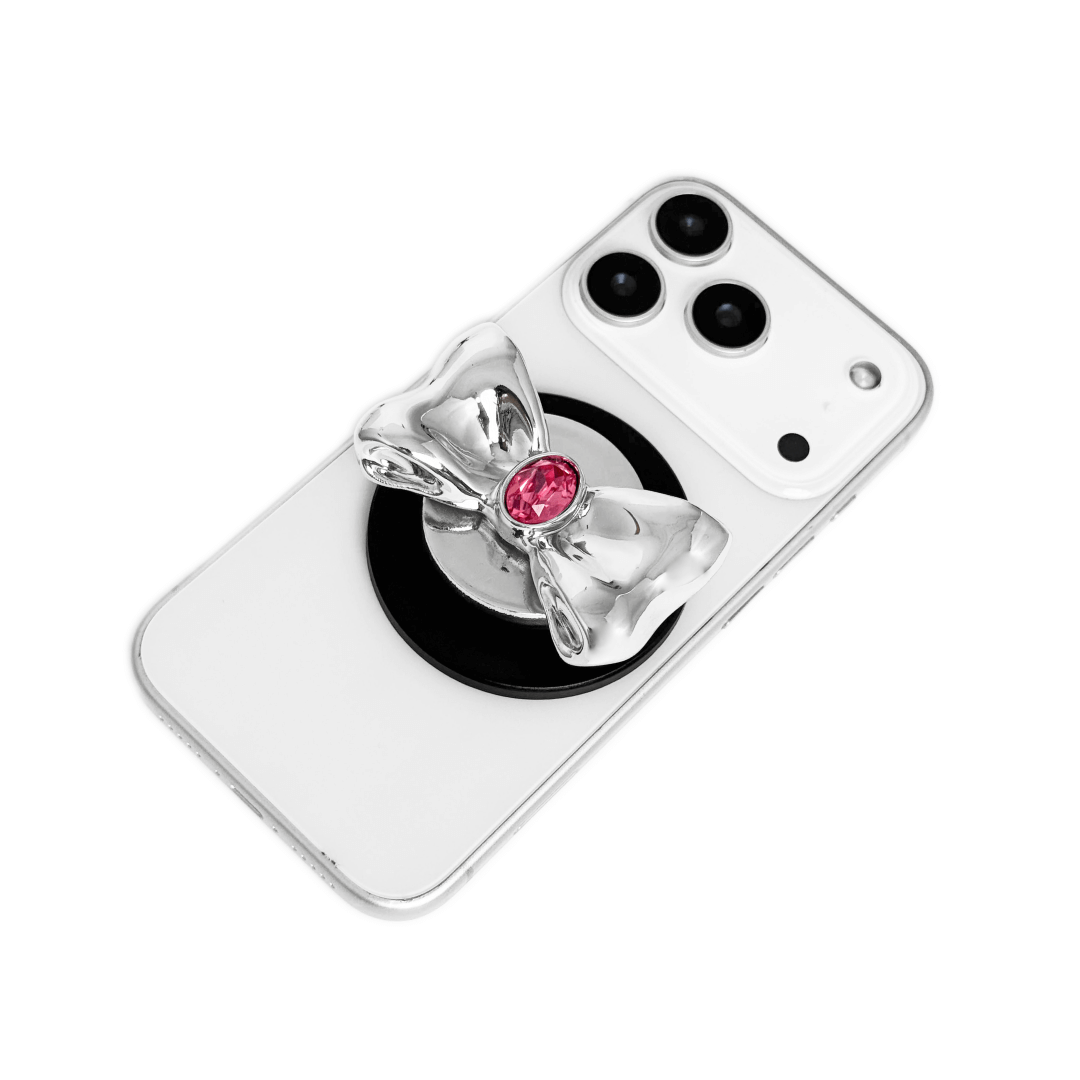 Gem Bow Phone Grip S available in silver, pink, black, and white bows, each featuring Swarovski crystal options: silver with pink, purple, white, blue, or black gems; pink with pink gem; black and white with black, white, or pink gems.