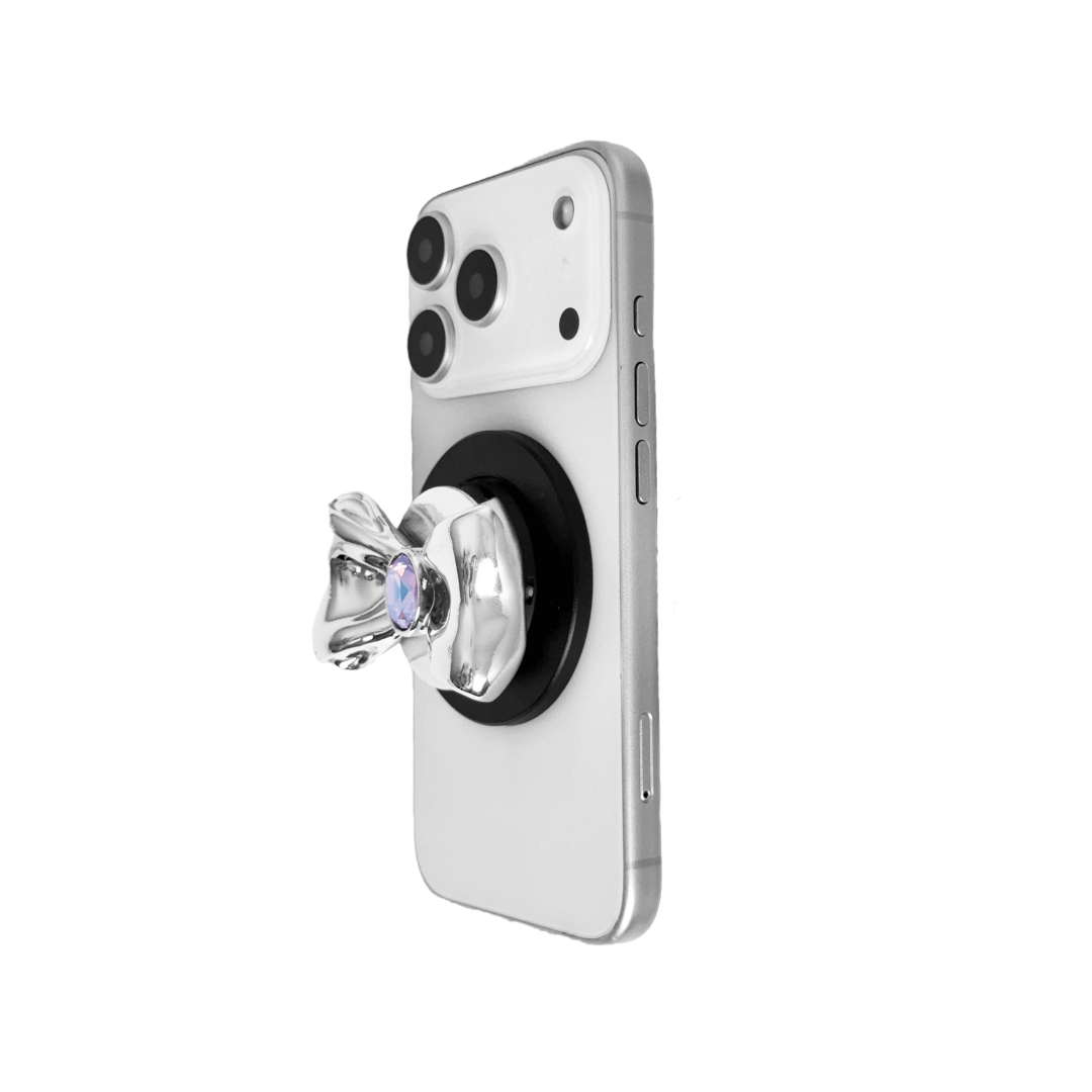 Gem Bow Phone Grip S available in silver, pink, black, and white bows, each featuring Swarovski crystal options: silver with pink, purple, white, blue, or black gems; pink with pink gem; black and white with black, white, or pink gems.