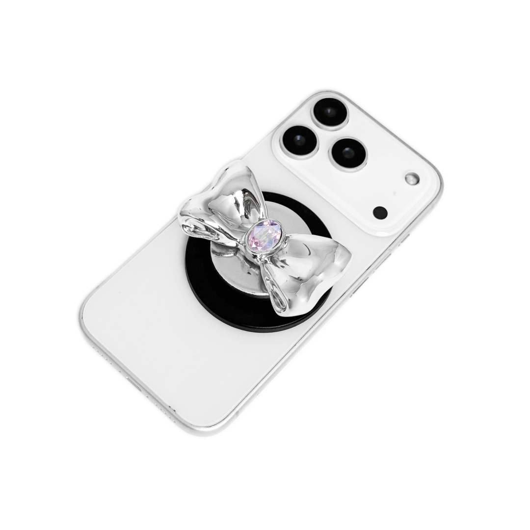 Gem Bow Phone Grip S available in silver, pink, black, and white bows, each featuring Swarovski crystal options: silver with pink, purple, white, blue, or black gems; pink with pink gem; black and white with black, white, or pink gems.