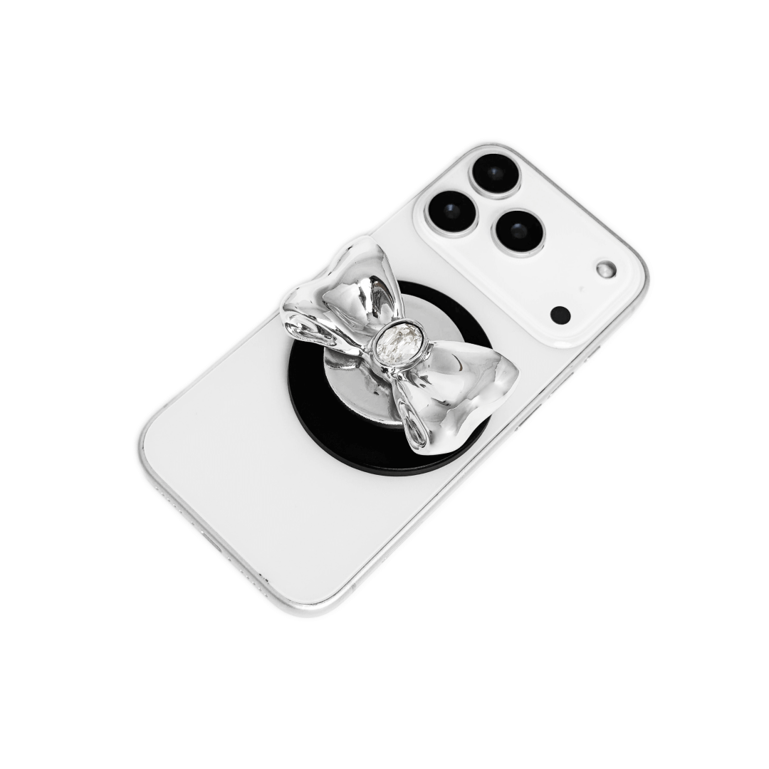 Gem Bow Phone Grip S available in silver, pink, black, and white bows, each featuring Swarovski crystal options: silver with pink, purple, white, blue, or black gems; pink with pink gem; black and white with black, white, or pink gems.