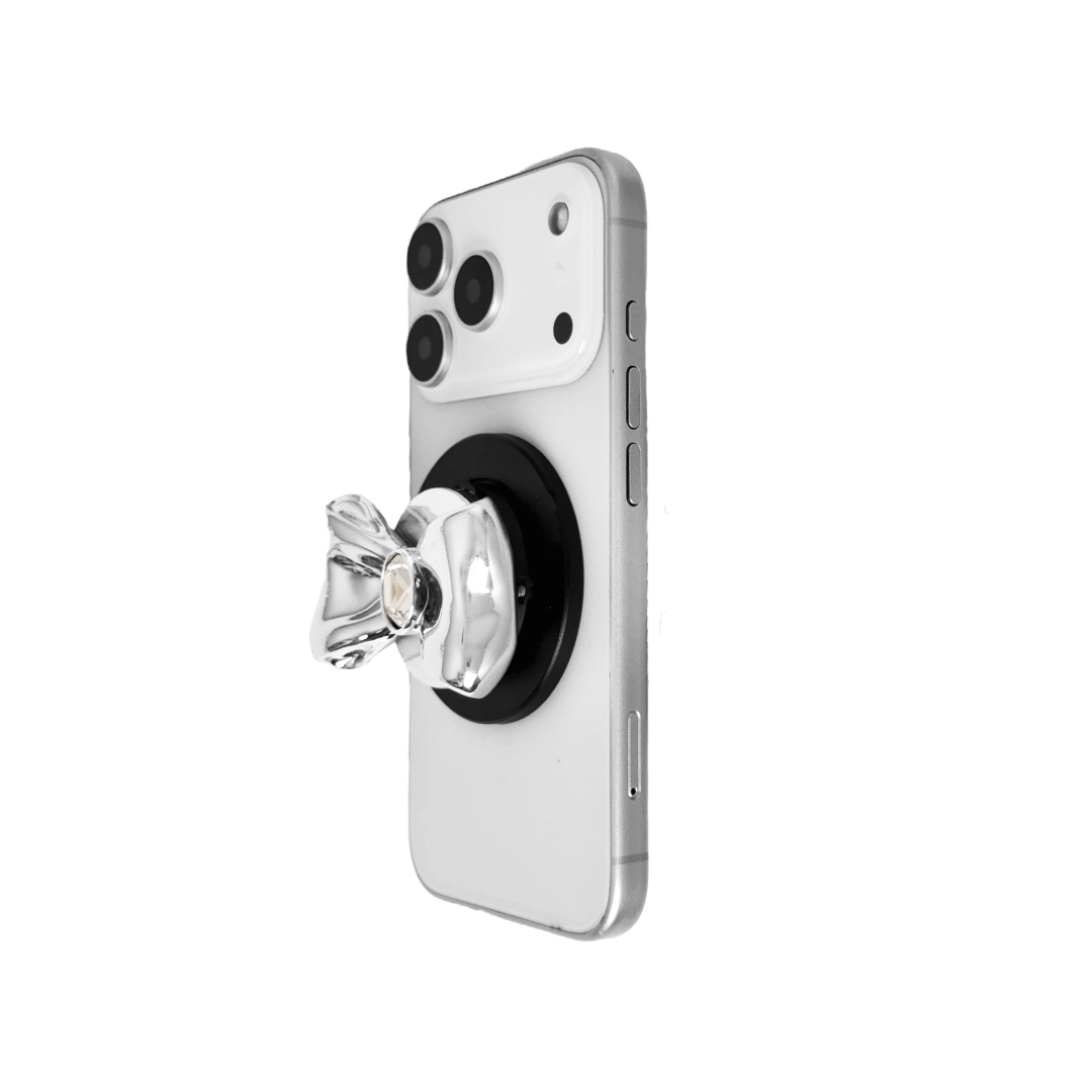 Gem Bow Phone Grip S available in silver, pink, black, and white bows, each featuring Swarovski crystal options: silver with pink, purple, white, blue, or black gems; pink with pink gem; black and white with black, white, or pink gems.