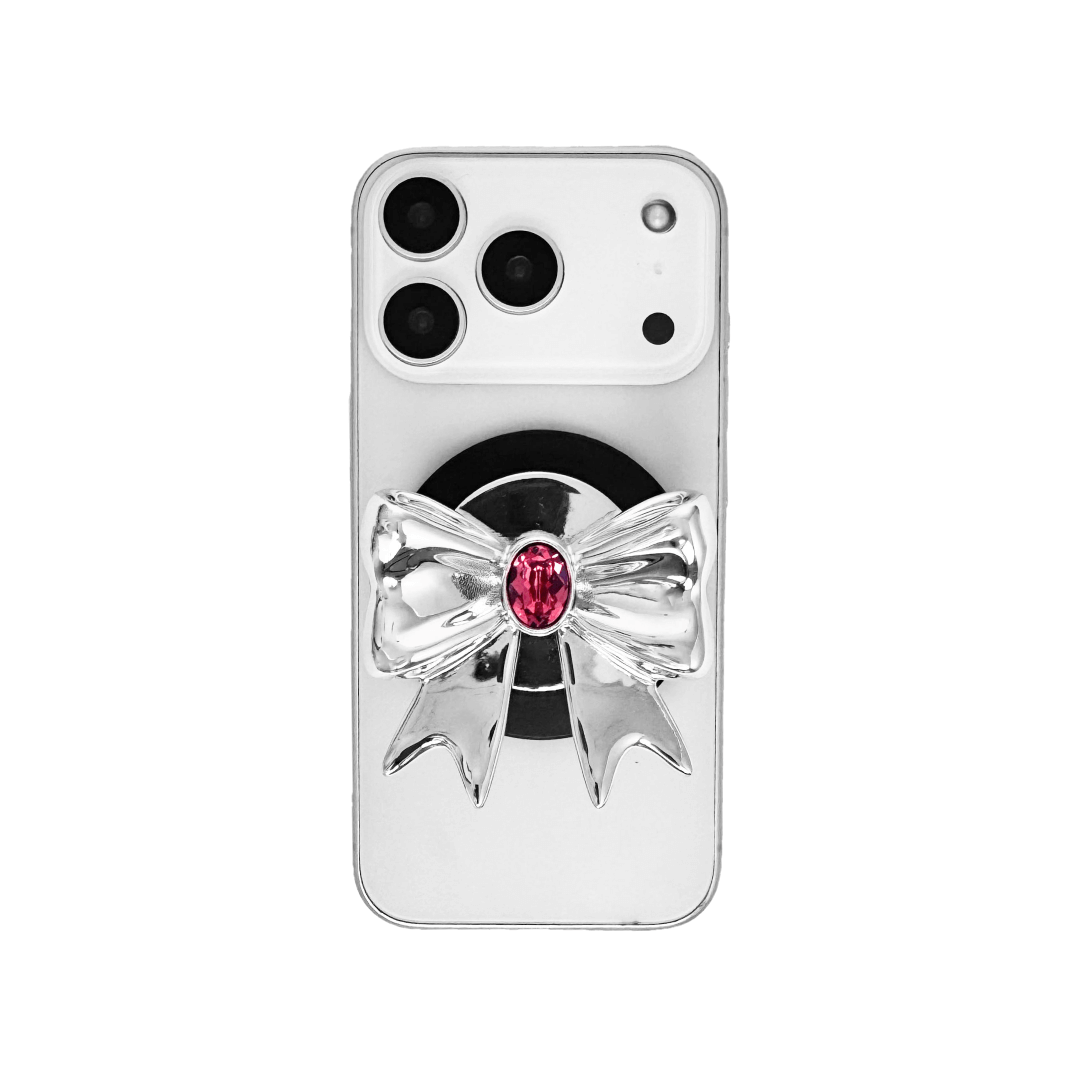 Gem Ribbon Phone Grip S available in silver, pink, black, and white ribbon designs, each featuring Swarovski crystal options: silver with pink, purple, white, blue, or black gems; pink with pink gem; black and white with black, white, or pink gems.