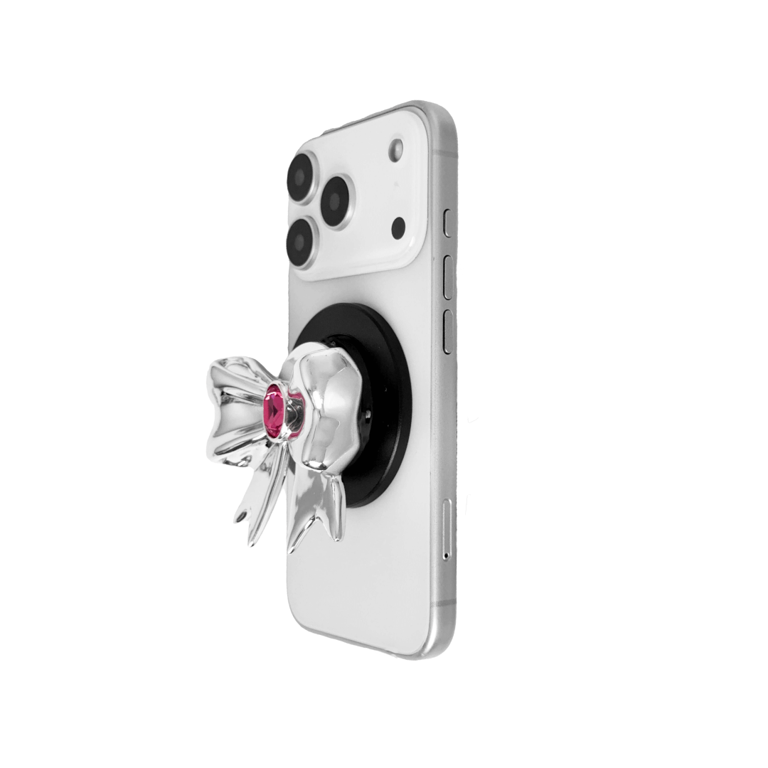 Gem Ribbon Phone Grip S available in silver, pink, black, and white ribbon designs, each featuring Swarovski crystal options: silver with pink, purple, white, blue, or black gems; pink with pink gem; black and white with black, white, or pink gems.