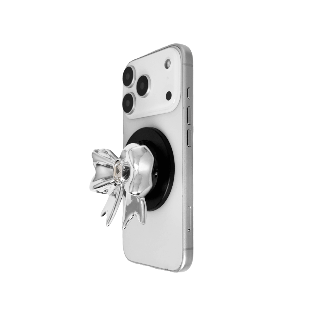 Gem Ribbon Phone Grip S available in silver, pink, black, and white ribbon designs, each featuring Swarovski crystal options: silver with pink, purple, white, blue, or black gems; pink with pink gem; black and white with black, white, or pink gems.