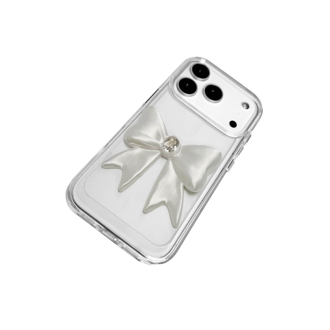 The Glossy White Gem Bow iPhone Case featuring the stunning 3D sculpted white bow with a central gem embellishment, shown on both the Crystal Clear (Transparent) and White Leather Texture base options.