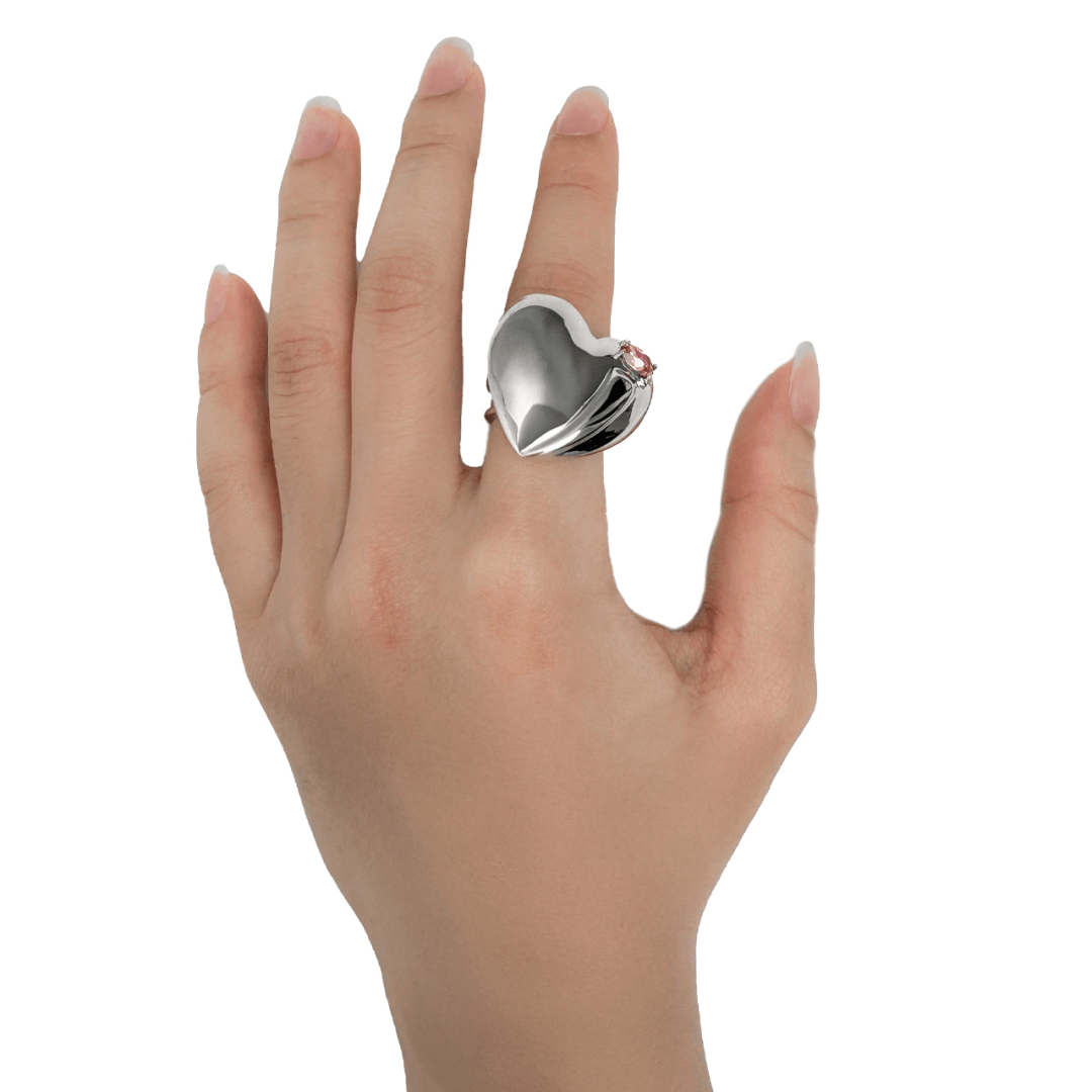 Slim band ring with a heart-shaped design and a pink Swarovski crystal centerpiece.