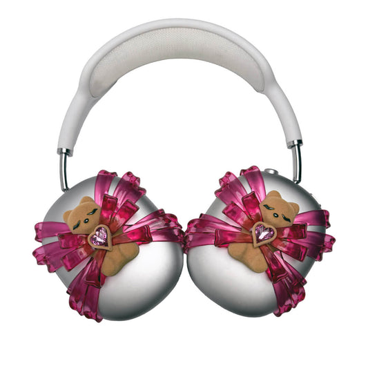 Ribbon Gummy Bear AirPods Max cover in Pink Edition, featuring a beige bear holding a pink crystal heart, surrounded by layered metallic pink ribbons.