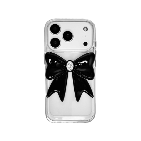 Midnight Gem Bow iPhone Case with 3D bow design, available in mirror silver and glossy black. Swarovski crystal centerpiece offered in black, white, or pink.