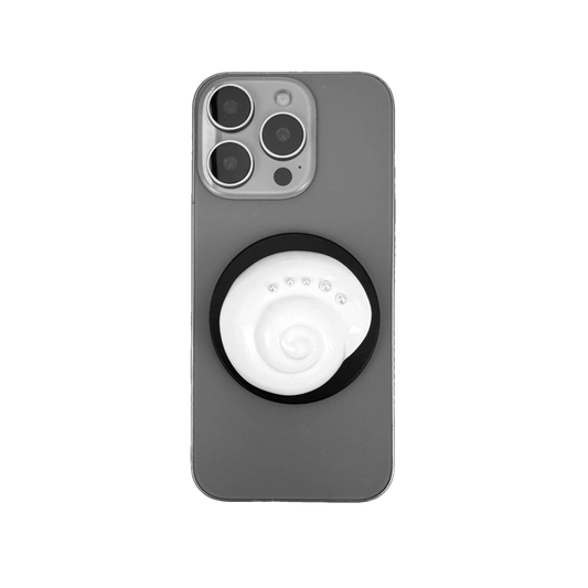 Glossy silver, white spiral shell phone grip with rhinestone accents – mounted on a matte black base and attached to a gray iPhone case