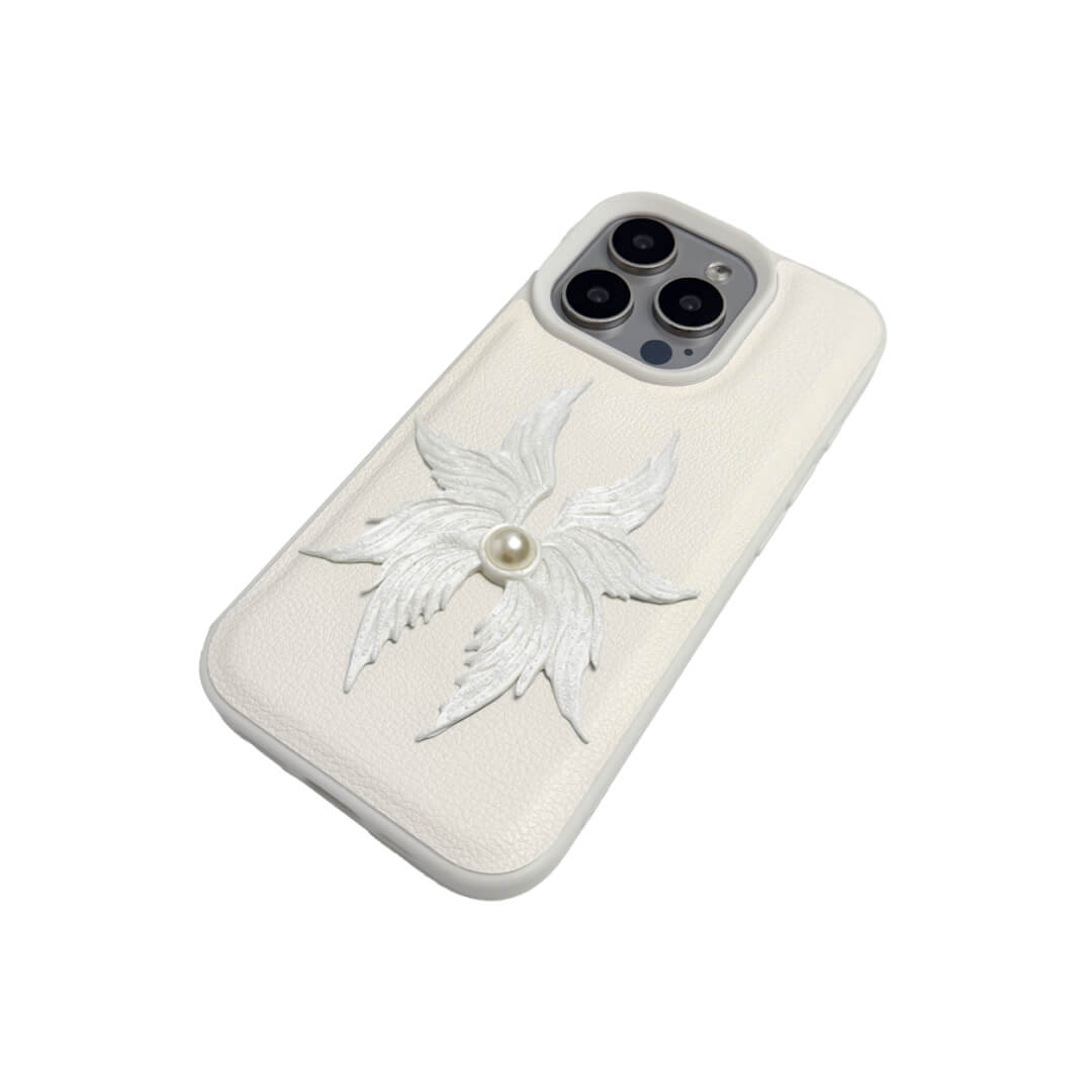 The Embroidered Angel Wings iPhone Case featuring intricate white feather/wing embroidery and a central pearl, shown on both the Crystal Clear (Transparent) and White Leather Texture base options.