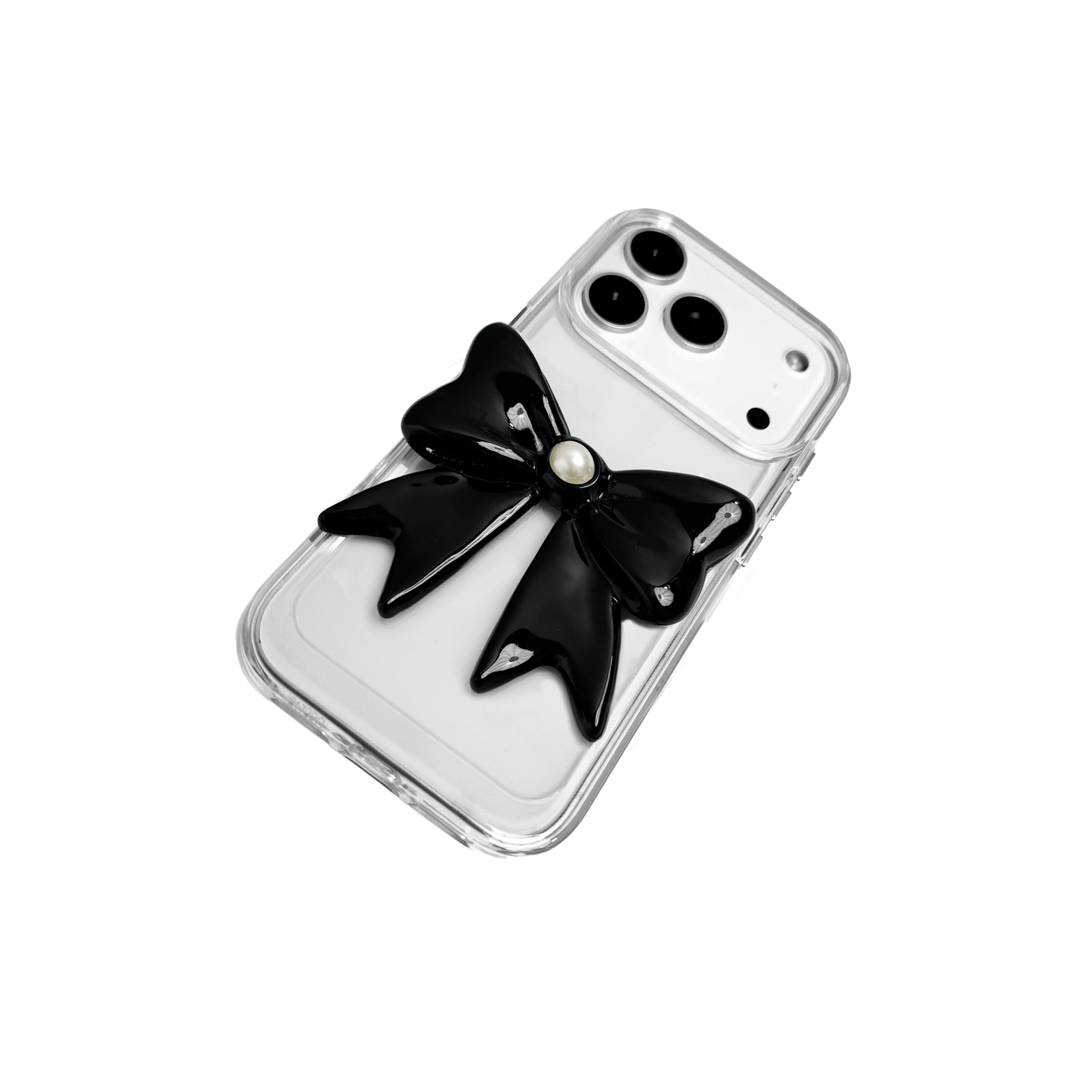A set of two iPhone cases, both featuring a large, 3D bow charm centered on the back. One case shows a black bow and the other a white bow, with a single white pearl embedded at the center of each bow. The phone cases appear to have a silver or transparent base.