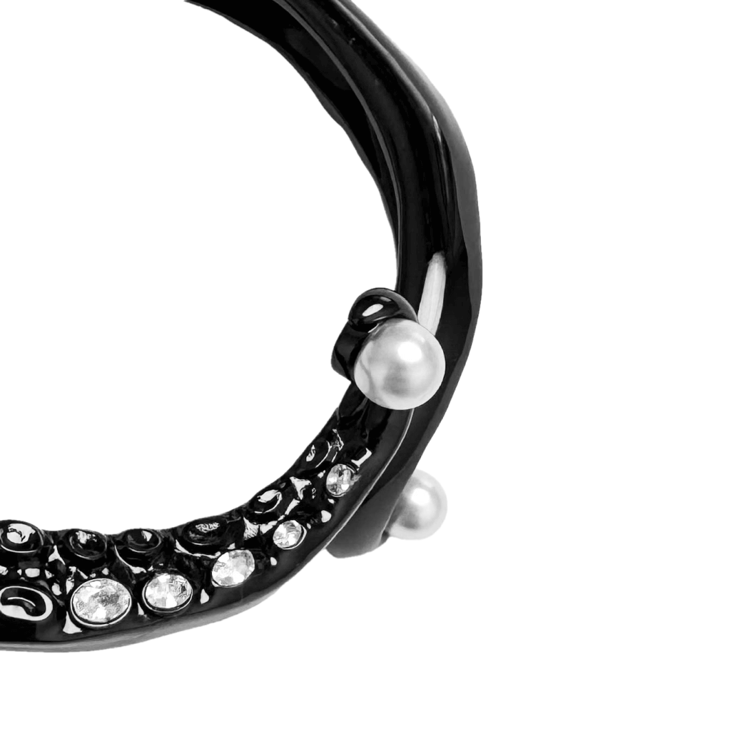 Black and silver octopus-inspired bracelet with pearl detail.