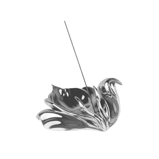 Futuristic chrome incense holder with flowing petal silhouette – organic metallic design cradling incense stick in sculptural bloom