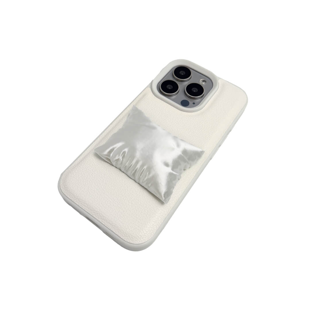 Two Pillow iPhone Cases: one with a transparent case and one with a white lychee leather case. Both feature the 3D sculpted silver/white pillow detail.