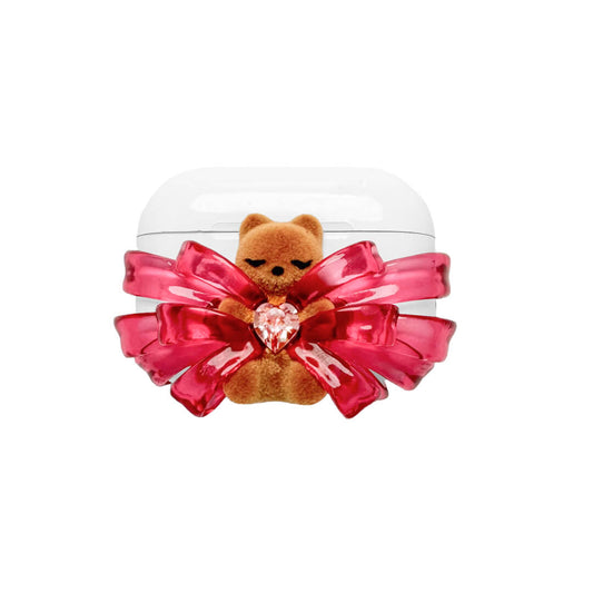 Ribbon Magic Bear AirPods Cover featuring a beige gummy bear with closed eyes, holding a pink crystal heart, framed by layered translucent pink ribbons.
