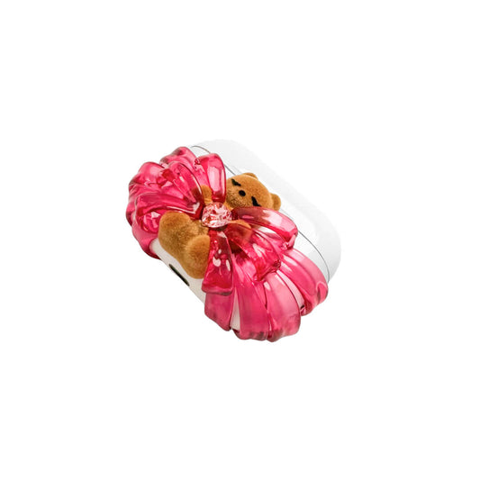 Ribbon Magic Bear AirPods Cover featuring a beige gummy bear with closed eyes, holding a pink crystal heart, framed by layered translucent pink ribbons.
