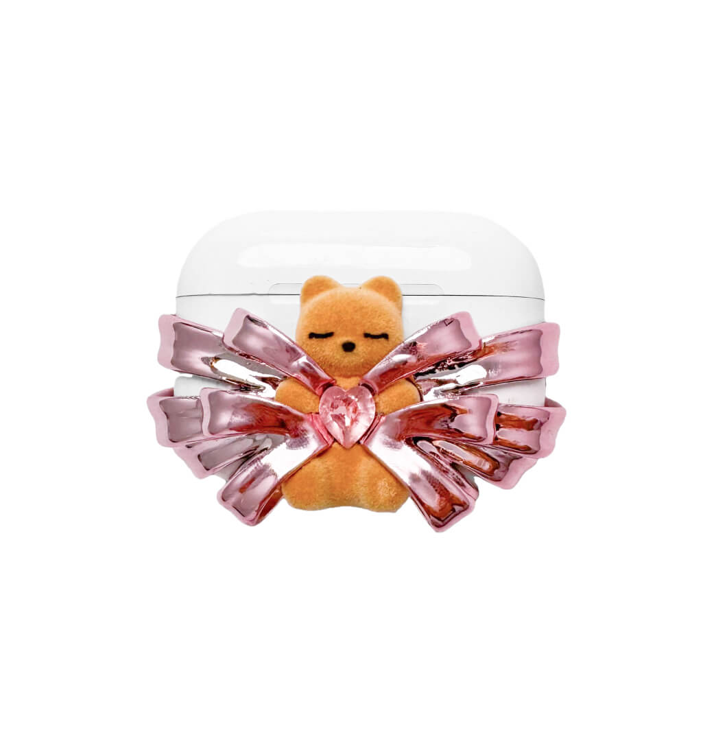 Ribbon Magic Bear AirPods Cover featuring a beige gummy bear with closed eyes, holding a pink crystal heart, framed by layered translucent pink ribbons.