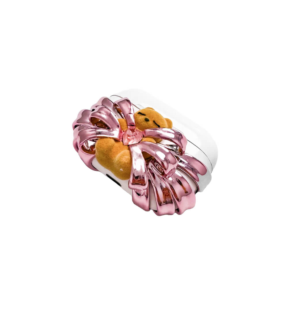 Ribbon Magic Bear AirPods Cover featuring a beige gummy bear with closed eyes, holding a pink crystal heart, framed by layered translucent pink ribbons.