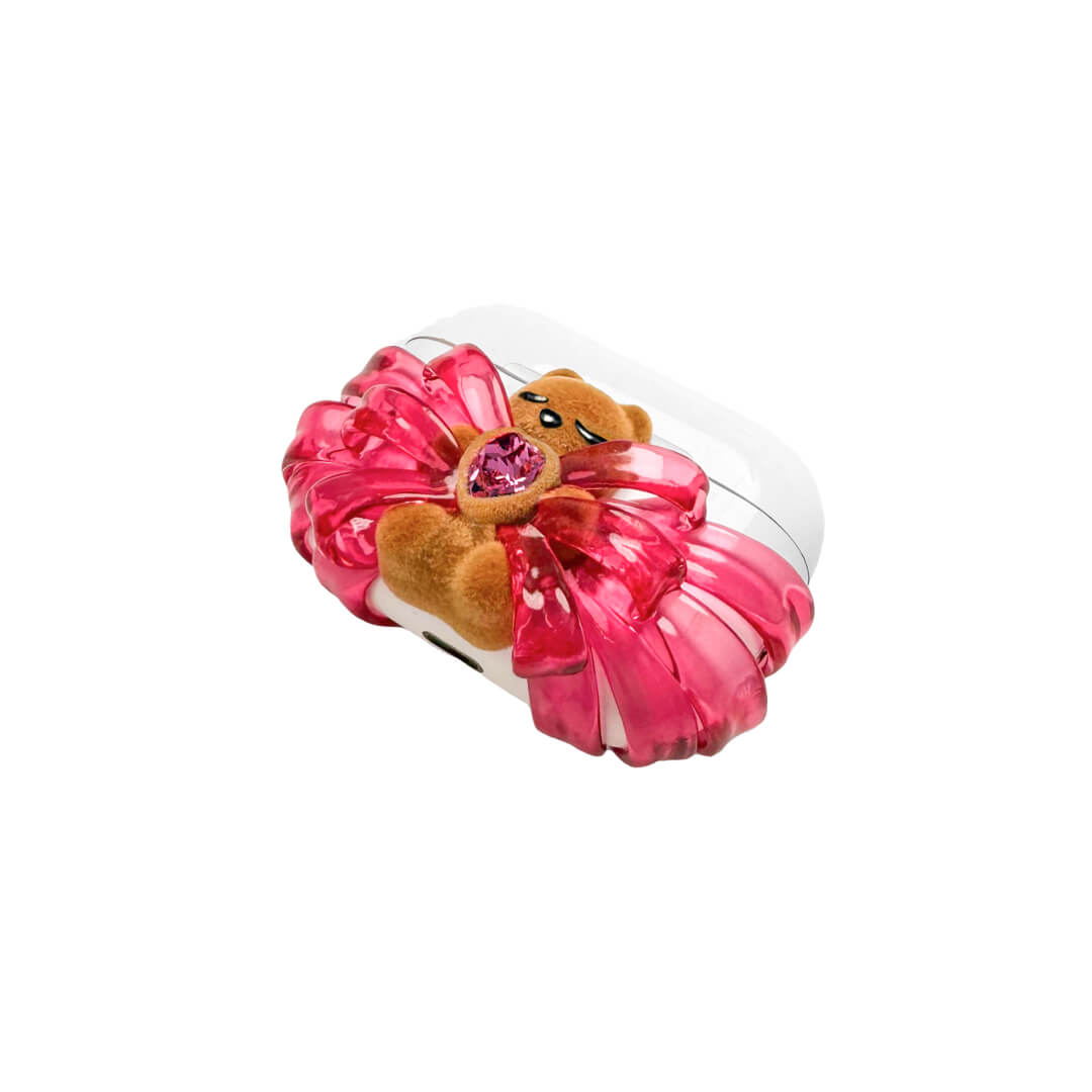 Ribbon Magic Bear AirPods Cover featuring a beige gummy bear with closed eyes, holding a pink crystal heart, framed by layered translucent pink ribbons.