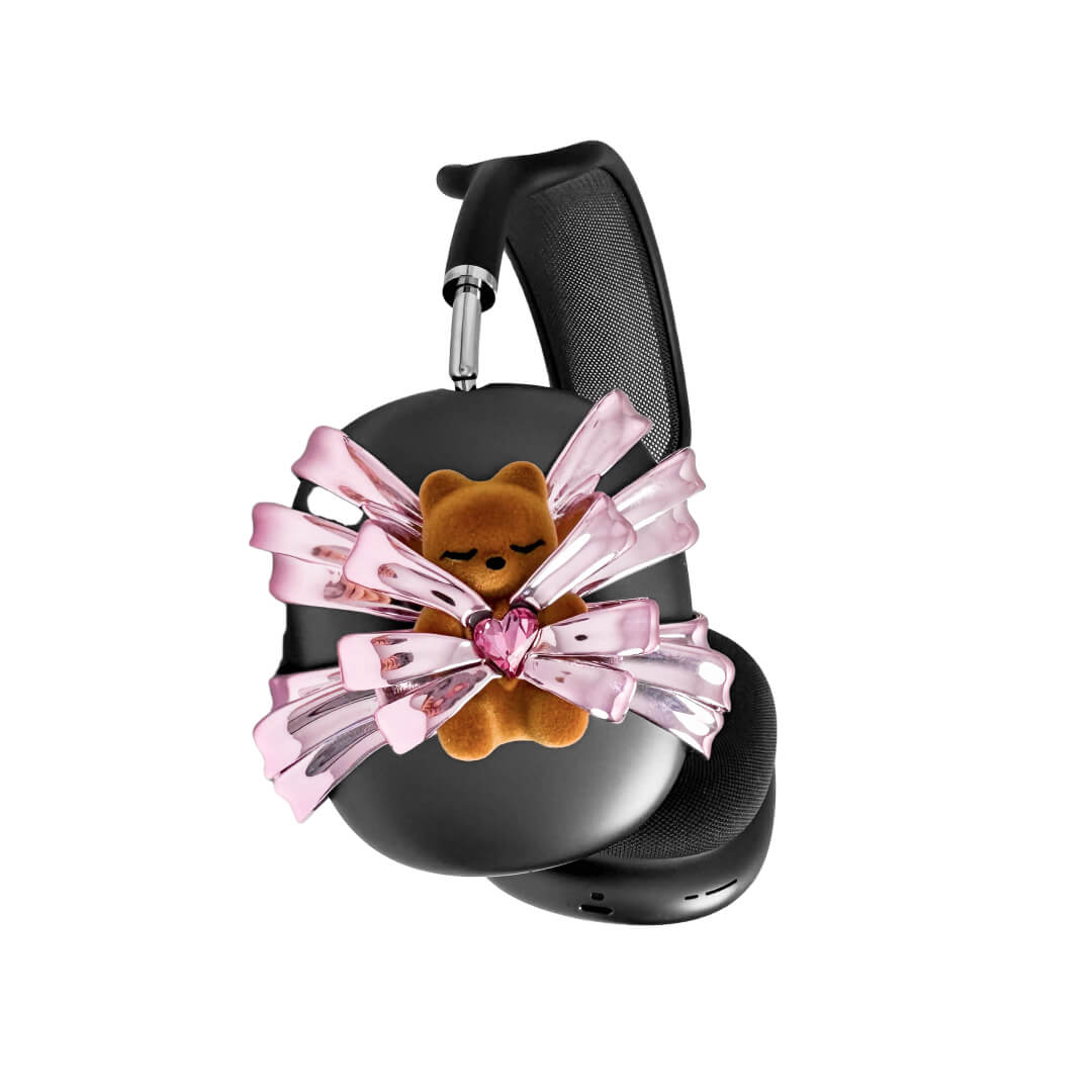 Ribbon Gummy Bear AirPods Max cover in Pink Edition, featuring a beige bear holding a pink crystal heart, surrounded by layered metallic pink ribbons.