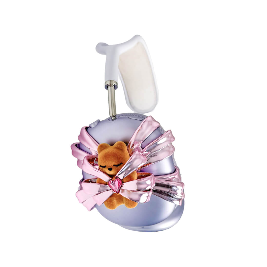 Ribbon Gummy Bear AirPods Max cover in Pink Edition, featuring a beige bear holding a pink crystal heart, surrounded by layered metallic pink ribbons.