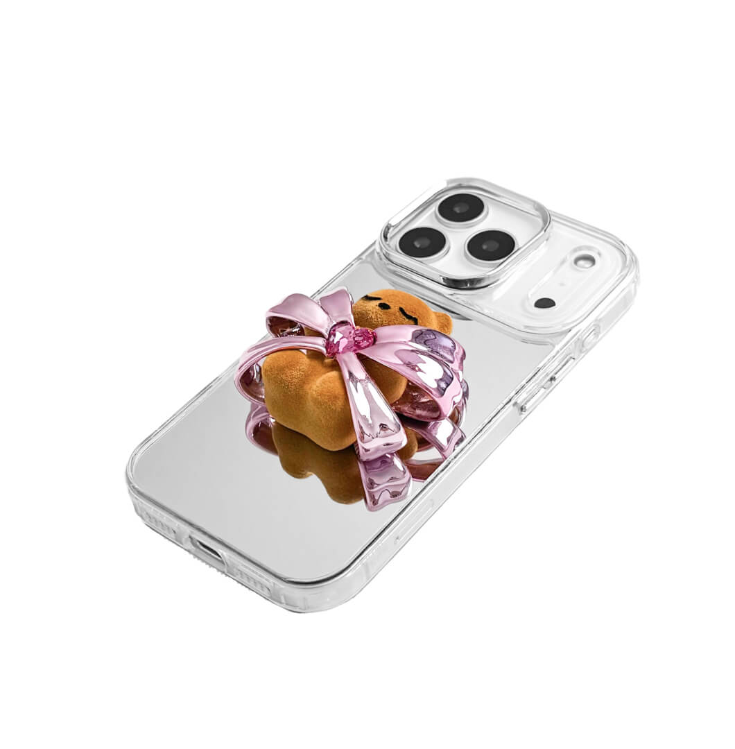 Ribbon Magic Bear iPhone Case – Pink Edition featuring a beige gummy bear holding a pink crystal heart, framed by shimmering metallic pink ribbons.