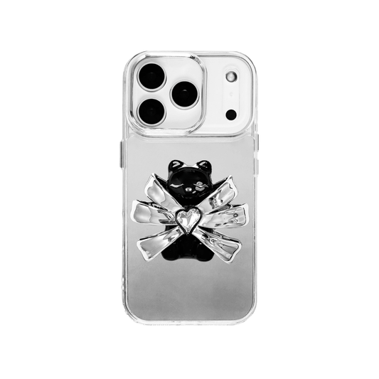 Ribbon Magic Bear iPhone Case featuring a black gummy bear holding a clear crystal heart, framed by metallic silver ribbon accents.