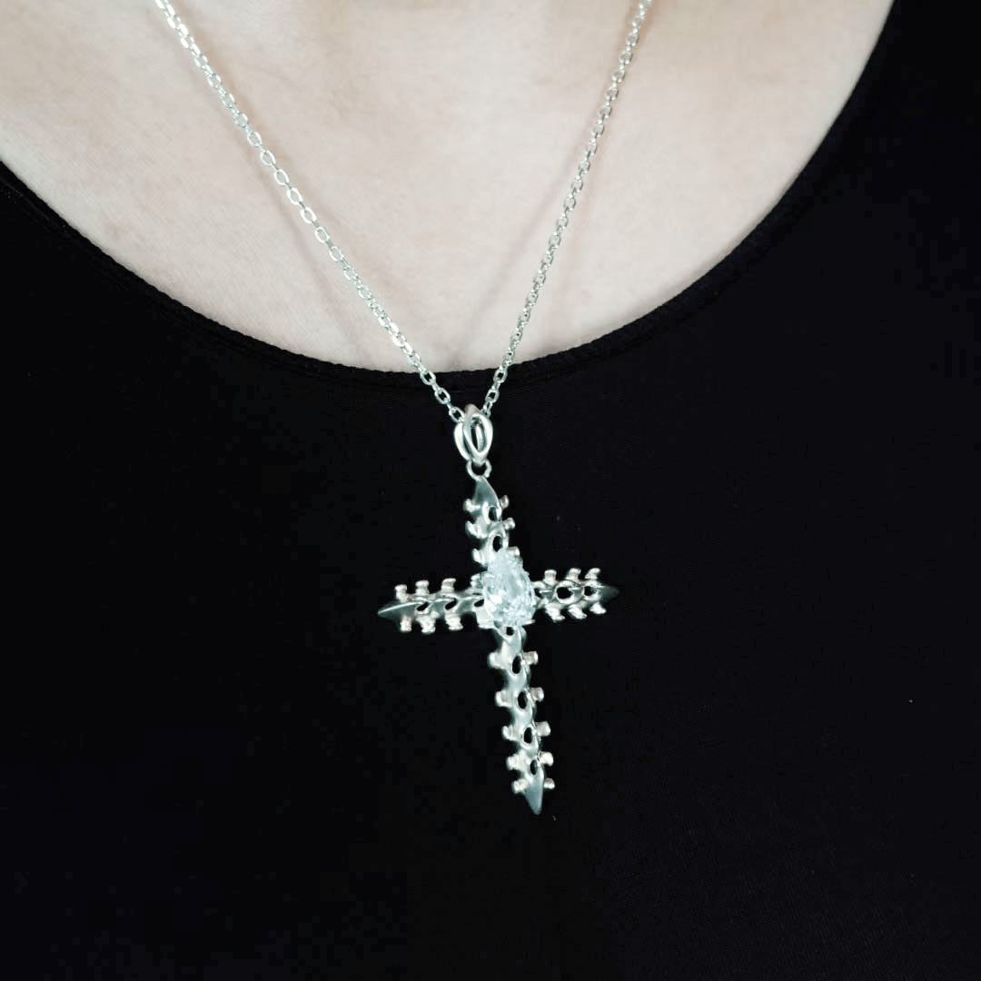 Discover the SPiNE CROSS NECKLACE, a luxurious unisex necklace featuring a distinctive skeleton-inspired cross design with diamond accents. Perfect for those seeking high-end, bold, and elegant accessories.