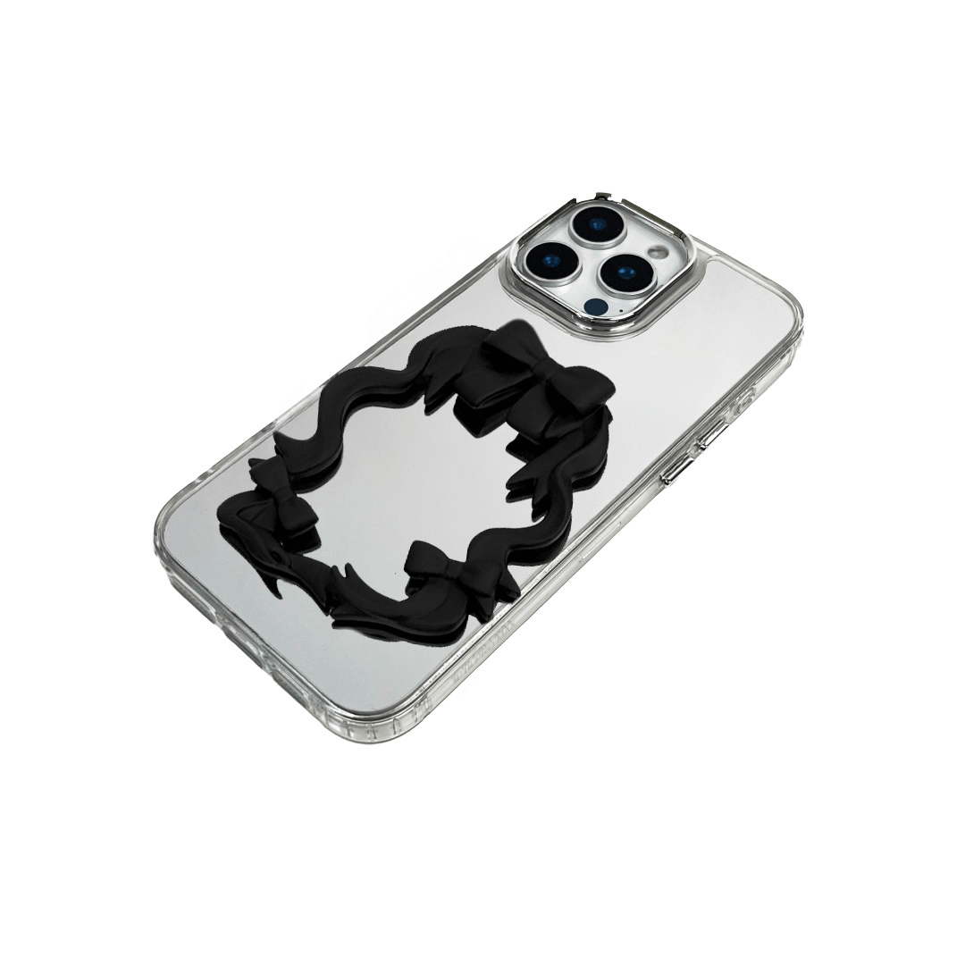Mirror phone case with sculpted pink, silver, black and white bows and ribbon frame design, creating a romantic, soft-glam look.