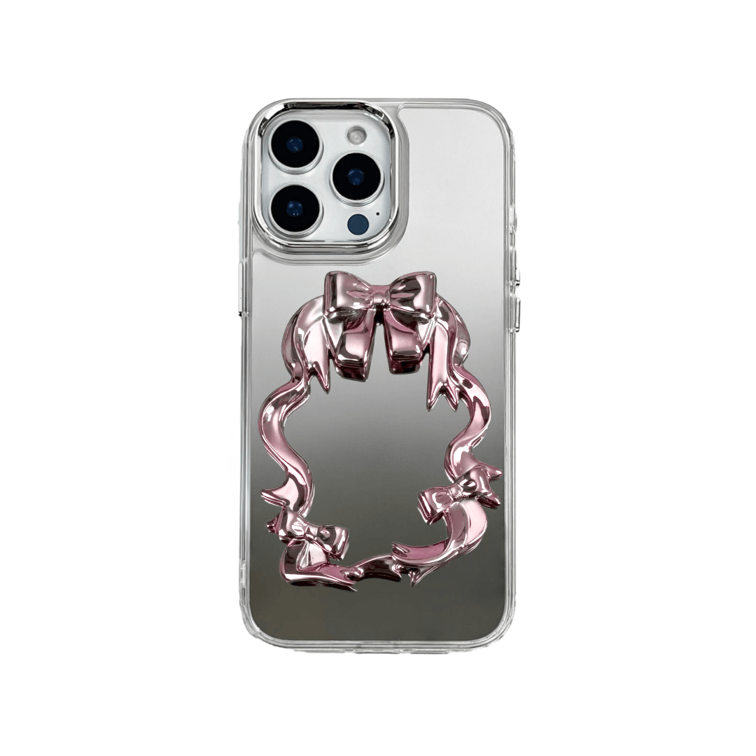 Mirror phone case with sculpted pink, silver, black and white bows and ribbon frame design, creating a romantic, soft-glam look.