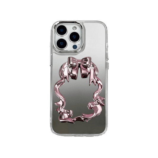 Mirror phone case with sculpted pink, silver, black and white bows and ribbon frame design, creating a romantic, soft-glam look.
