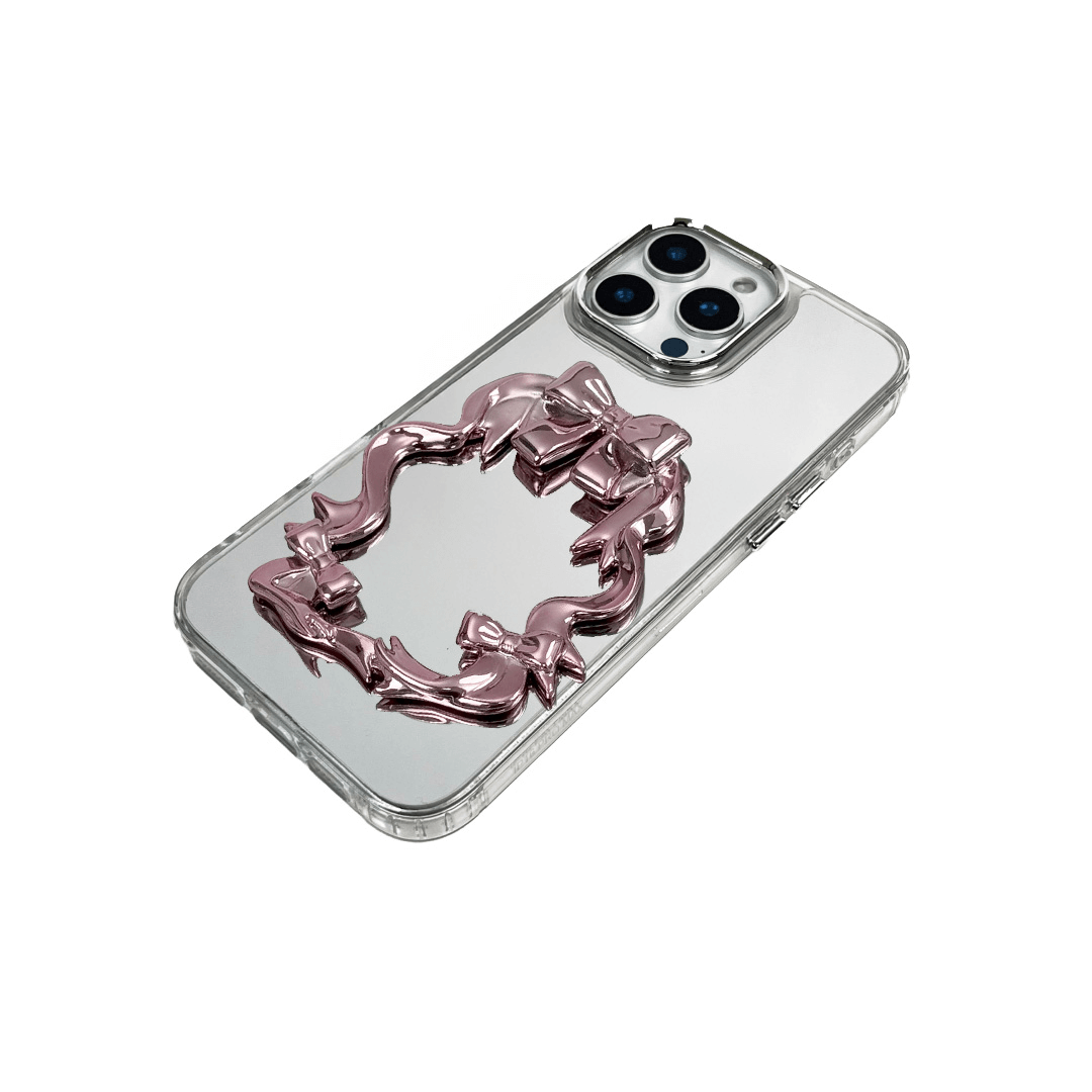 Mirror phone case with sculpted pink, silver, black and white bows and ribbon frame design, creating a romantic, soft-glam look.