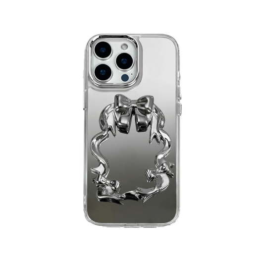 Mirror phone case with sculpted pink, silver, black and white bows and ribbon frame design, creating a romantic, soft-glam look.