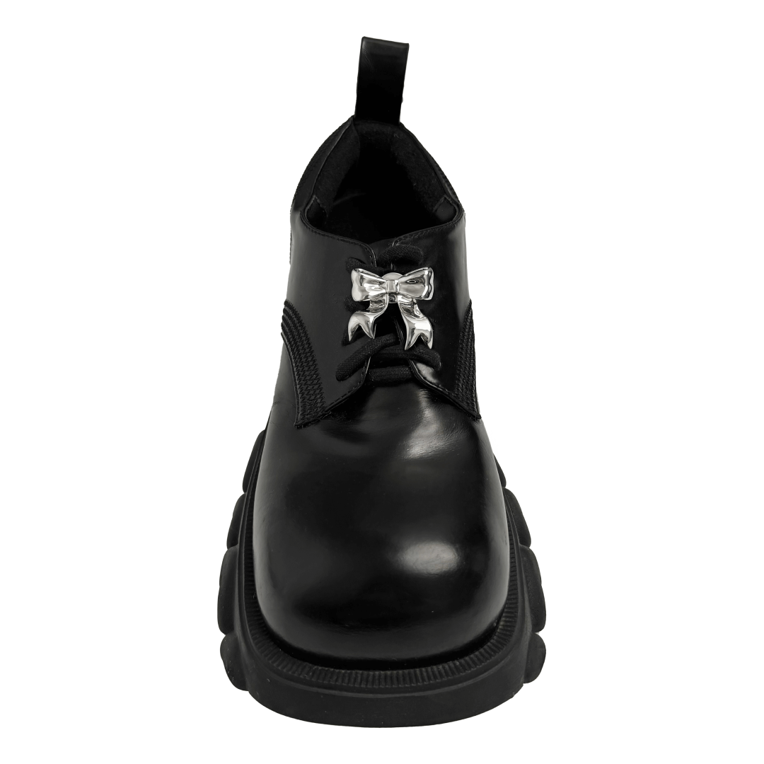 A silver metallic silken ribbon shoelace charm with flowing curves, giving a graceful and delicate accent to sneakers.