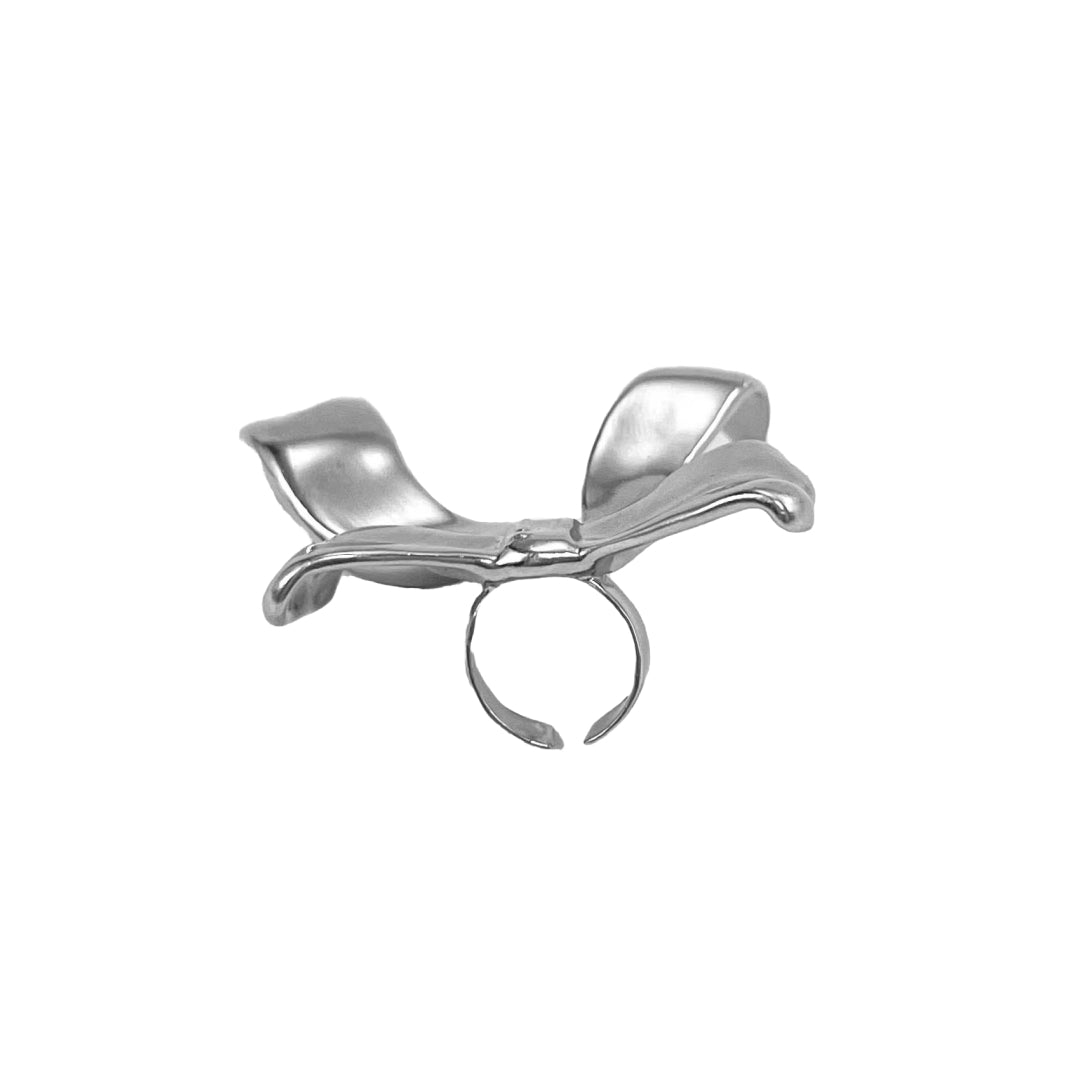 Polished silver bow-shaped accessory attached to the side of black AirPods Max headphones.