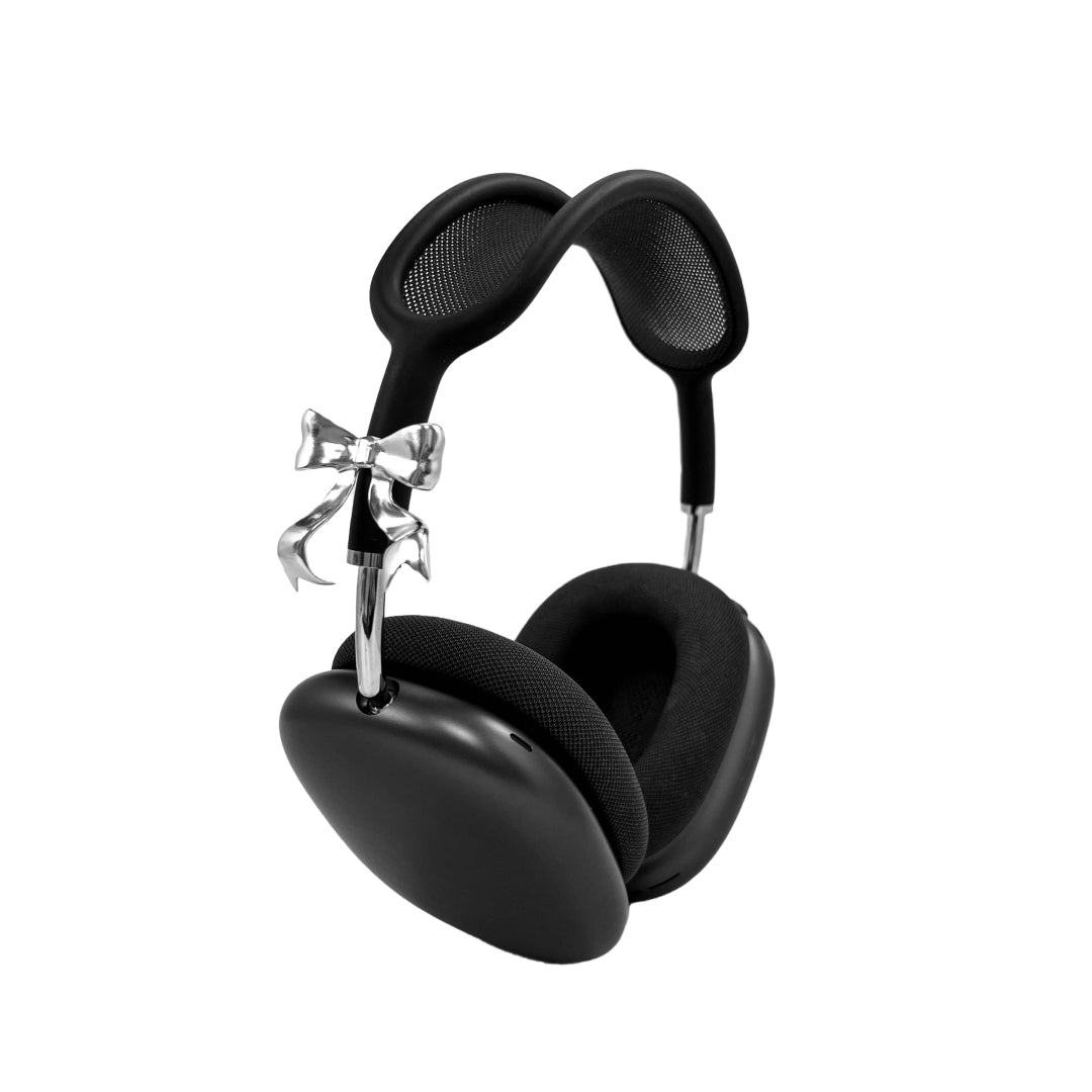 Polished silver bow-shaped accessory attached to the side of black AirPods Max headphones.