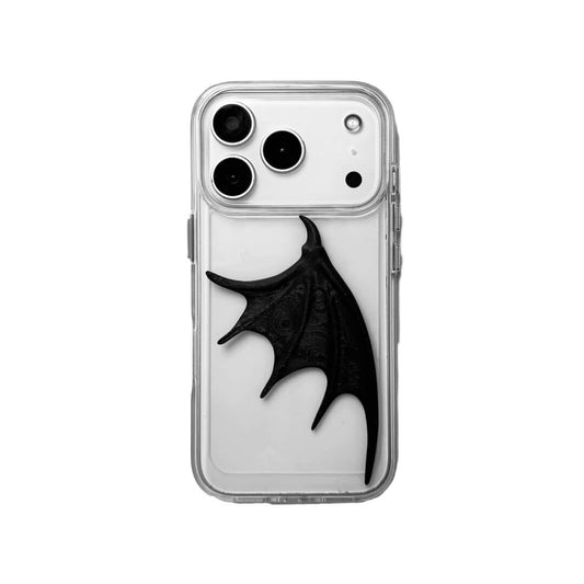 A high-fashion iPhone case featuring a large, 3D-printed single demon wing with a natural matte black finish. The design is presented in two styles: an asymmetric wing on a Clear Transparent base, and the same sculptural wing on a Black Leather textured base, showcasing a moody and avant-garde aesthetic.