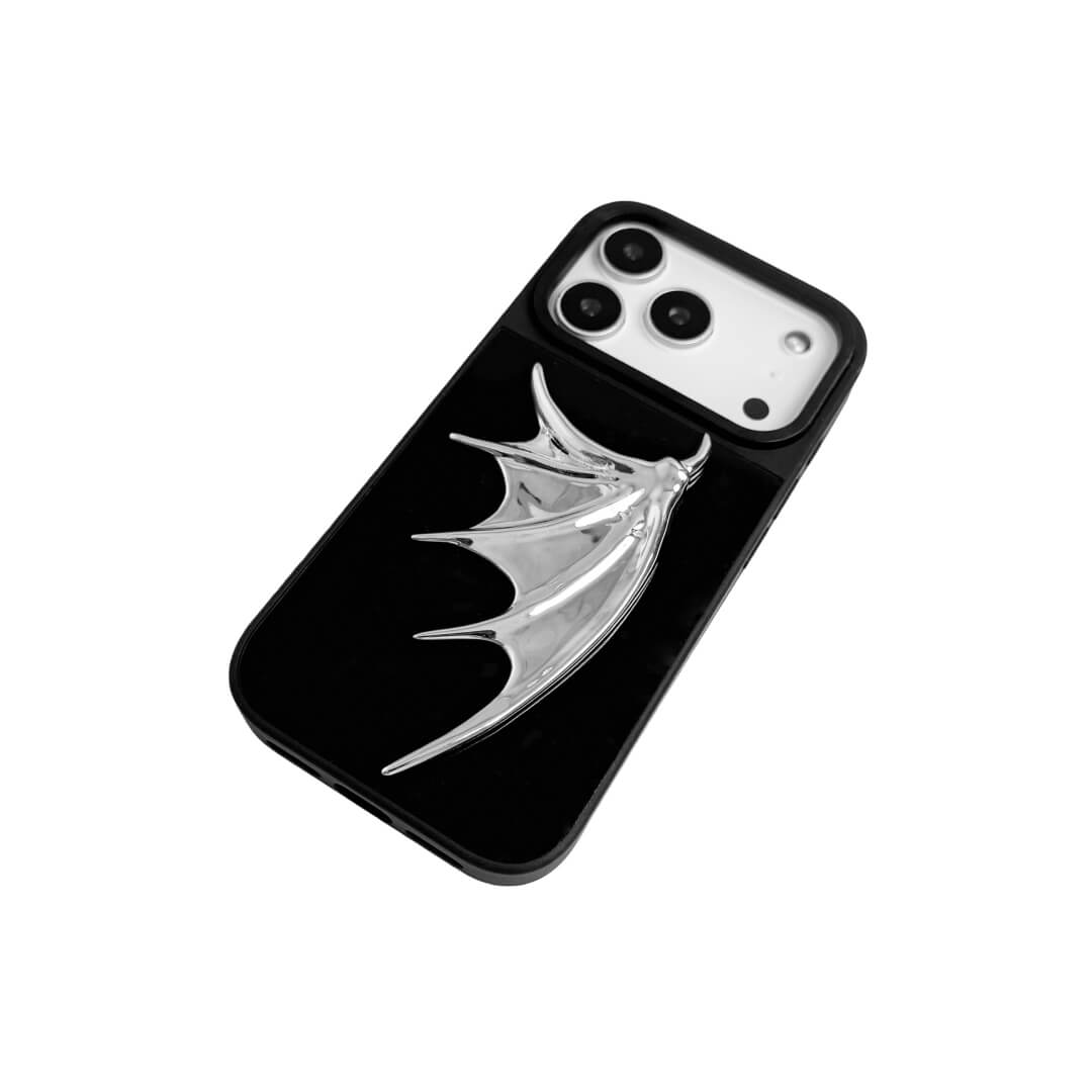 The Single Silver Demon Wing iPhone Case featuring a 3D sculpted silver metallic wing positioned on one side with a high-shine chrome finish. Shown in three base variations: Silver, Transparent, and Black.