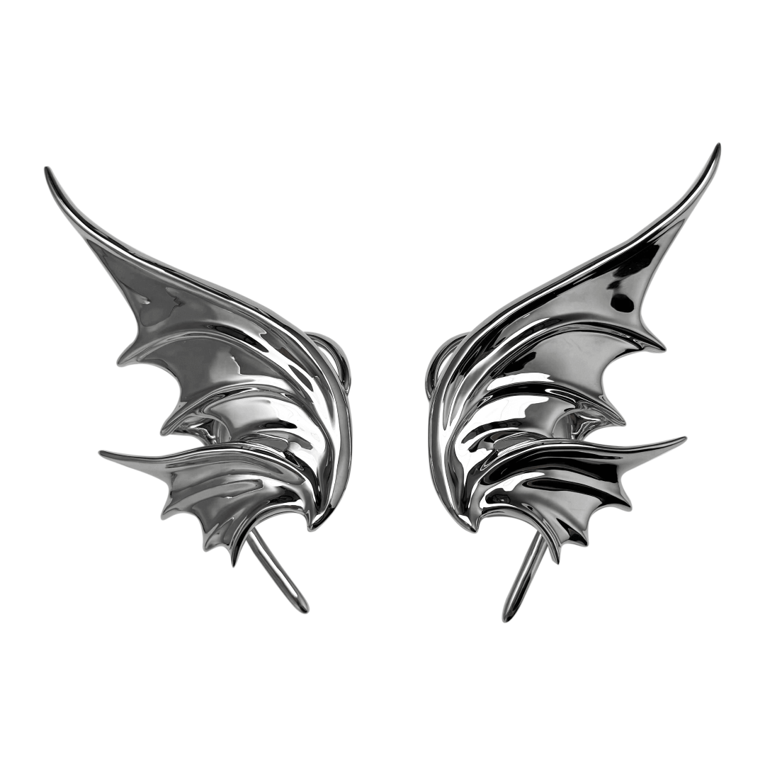 Pair of metallic bat-shaped earrings on a white background
