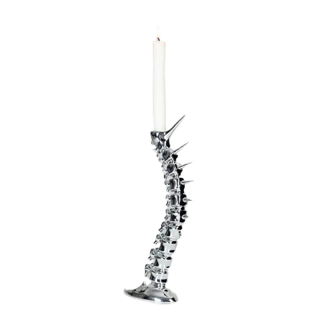 Futuristic chrome candleholder in biomorphic spinal-column form – sculptural vertebrae base studded with tiny climber figures ascending its curved backbone