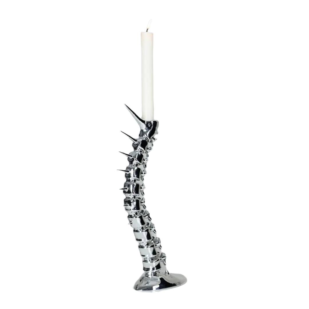 Futuristic chrome candleholder in biomorphic spinal-column form – sculptural vertebrae base studded with tiny climber figures ascending its curved backbone