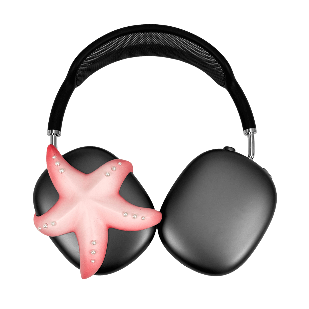 Apple over-ear headphones adorned with a metallic starfish sculpture and dot-like spheres, evoking constellations and marine elegance.