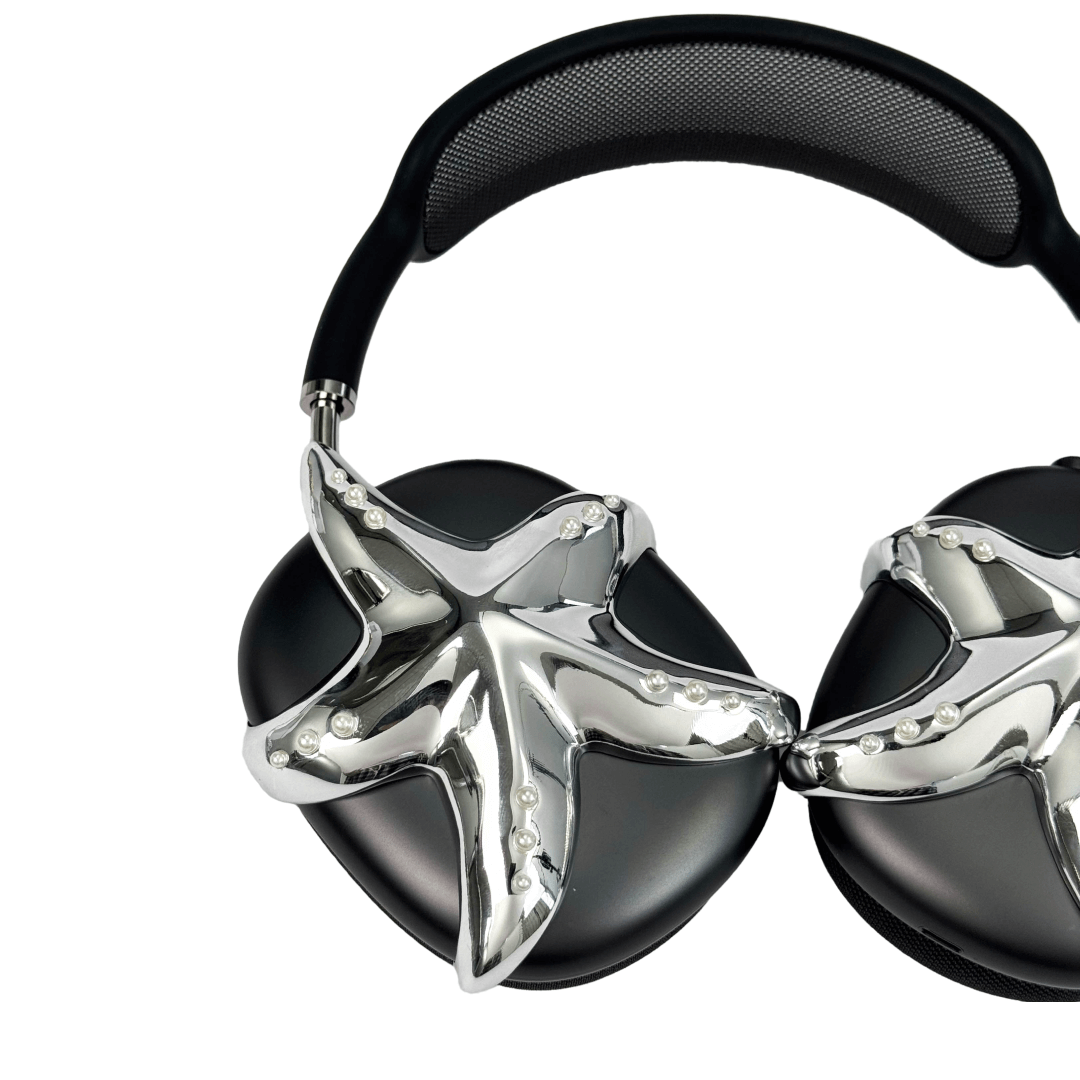 Apple over-ear headphones adorned with a metallic starfish sculpture and dot-like spheres, evoking constellations and marine elegance.